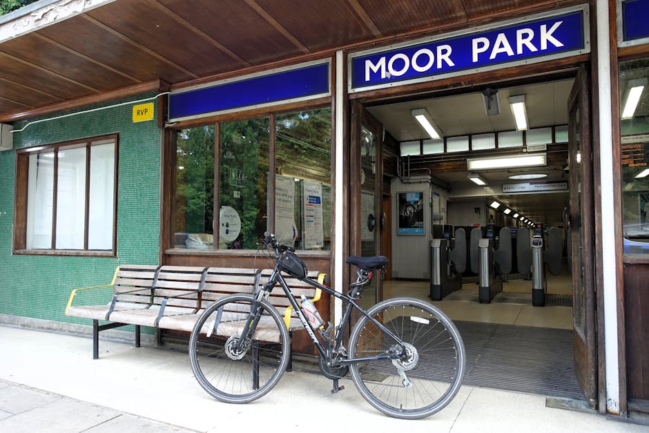 Image of Finsbury Park train station platform featuring a row of metal benches with wooden seats, under a large, white corrugated metal roof. The platform surface is made of concrete, appearing clean 